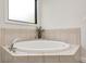 Bright bathroom featuring a soaking tub with tile surround and decorative accents at 16285 Remington Dr, Fishers, IN 46037