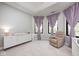 Bright Bedroom featuring a tray ceiling, soft purple curtains, and a comfortable recliner at 16285 Remington Dr, Fishers, IN 46037