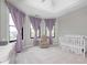 Bright Bedroom featuring a tray ceiling, soft purple curtains, and large windows at 16285 Remington Dr, Fishers, IN 46037