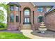 Grand brick home with an arched entryway, fountain, and manicured landscaping at 16285 Remington Dr, Fishers, IN 46037