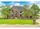 Majestic brick home featuring a well-manicured lawn and a charming water fountain at 16285 Remington Dr, Fishers, IN 46037