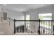 Upstairs hallway overlooking the living room, with a lake view through large windows at 16285 Remington Dr, Fishers, IN 46037