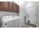Functional laundry room with washer, dryer, overhead cabinets, and exterior access door at 16285 Remington Dr, Fishers, IN 46037