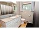 Updated bathroom with modern white vanity, granite countertop, and large mirror at 1701 Lincoln Rd, Speedway, IN 46224
