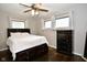 Bedroom features a queen bed, dark wood floors, chest of drawers and a ceiling fan at 1701 Lincoln Rd, Speedway, IN 46224