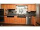 Traditional-style kitchen features wooden cabinets, black countertops, and stainless steel appliances at 1701 Lincoln Rd, Speedway, IN 46224