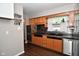 Traditional-style kitchen features wooden cabinets, black countertops, and stainless steel appliances at 1701 Lincoln Rd, Speedway, IN 46224