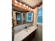 Bathroom vanity featuring dark wood cabinet, sink, frameless mirror, and matching accessories at 1949 Shenandoah Pl, Indianapolis, IN 46229