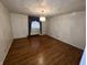 This bedroom features wood floors, a decorative light fixture, and a window with blue curtains at 1949 Shenandoah Pl, Indianapolis, IN 46229