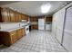 Functional kitchen with tile floors, wooden cabinets, and modern appliances including a washer and dryer at 1949 Shenandoah Pl, Indianapolis, IN 46229