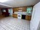 A classic kitchen featuring wood cabinets and white appliances that opens to a cozy living space at 1949 Shenandoah Pl, Indianapolis, IN 46229
