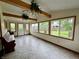 Bright sunroom featuring wood beam accents, tiled floor and a wall of windows offering backyard views at 1949 Shenandoah Pl, Indianapolis, IN 46229