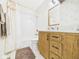 Bathroom with a vanity cabinet, sink, toilet, shower and tub combination featuring neutral patterned wallpaper at 209 E 35Th St, Anderson, IN 46013