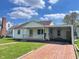 Charming single-story home features a welcoming front porch, carport, and beautiful brick driveway at 209 E 35Th St, Anderson, IN 46013