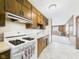 Efficient kitchen with stove, cabinets, linoleum floors, and view of the living room at 209 E 35Th St, Anderson, IN 46013
