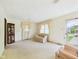 Spacious living room featuring neutral carpet, large windows, comfortable seating, and a glass display cabinet at 209 E 35Th St, Anderson, IN 46013