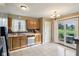 Functional kitchen with wood cabinetry, white appliances, and adjacent dining area with sliding glass doors at 2444 S Brandywine Ct, Greenfield, IN 46140