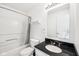 Well-lit bathroom with a shower-tub combo, modern vanity, and dark countertop at 2545 Harvest Moon Dr, Greenwood, IN 46143