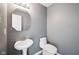Modern half bathroom with a pedestal sink, unique mirror, and gray painted walls at 2545 Harvest Moon Dr, Greenwood, IN 46143