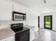 Bright kitchen featuring black appliances, access to the backyard, and ample counter space at 2545 Harvest Moon Dr, Greenwood, IN 46143