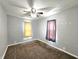 A cozy bedroom featuring gray walls, brown carpet, two windows, and a ceiling fan at 2737 S Roena St, Indianapolis, IN 46241