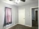 A cozy bedroom featuring gray walls, brown carpet, a window, and a white door at 2737 S Roena St, Indianapolis, IN 46241