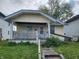 Cottage-style home with a covered porch, vinyl siding, a ramp, and mature trees in a suburban neighborhood at 2806 Jefferson St, Anderson, IN 46016