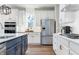 Stylish kitchen showcasing stainless steel appliances, white subway tile backsplash, and an island with blue cabinets at 3907 Goodwin Dr, Zionsville, IN 46077