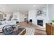 Cozy living room featuring hardwood floors, fireplace, modern decor, and open access to the dining area at 3907 Goodwin Dr, Zionsville, IN 46077
