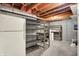 Unfinished basement space with shelving units and exposed ceiling at 3996 Brockton Manor N Dr, Greenwood, IN 46143