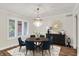 Elegant dining area featuring a round table, comfortable blue chairs, a statement chandelier and natural light at 3996 Brockton Manor N Dr, Greenwood, IN 46143