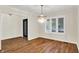 Open dining room featuring hardwood floors, elegant lighting, and large window with shutters at 3996 Brockton Manor N Dr, Greenwood, IN 46143