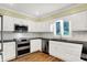Well-equipped kitchen with stainless steel appliances, white cabinets and a window over sink, complemented by a tiled backsplash at 3996 Brockton Manor N Dr, Greenwood, IN 46143