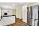 Bright kitchen with stainless steel refrigerator, black countertops and white cabinetry, flowing layout to fireplace area at 3996 Brockton Manor N Dr, Greenwood, IN 46143