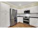Well-equipped kitchen with stainless appliances, ample white cabinetry, black countertops, and tile backsplash at 3996 Brockton Manor N Dr, Greenwood, IN 46143