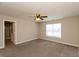 This carpeted bedroom features a ceiling fan, a window and a door leading to a bathroom with a shower at 4104 Bullfinch Way, Westfield, IN 46062