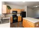 A lovely kitchen features an island, and black appliances alongside wooden cabinets and a view of the living room at 4104 Bullfinch Way, Westfield, IN 46062
