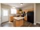 A lovely kitchen features an island, and black appliances alongside wooden cabinets and a door to the back at 4104 Bullfinch Way, Westfield, IN 46062