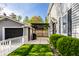 Backyard featuring a small patio with a black pergola, a garage, and green landscaping at 413 E 40Th St, Indianapolis, IN 46205