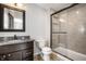 Bathroom with granite vanity, toilet, and tiled shower with a glass door at 413 E 40Th St, Indianapolis, IN 46205