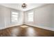 Empty bedroom with hardwood floors, ceiling fan and two windows with natural light at 413 E 40Th St, Indianapolis, IN 46205