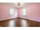 Bedroom with hardwood floors, ceiling fan, natural light from the two windows and pink walls at 413 E 40Th St, Indianapolis, IN 46205