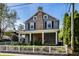 Charming two-story home featuring gray siding, brick chimney, a front porch, and a neatly manicured yard at 413 E 40Th St, Indianapolis, IN 46205