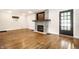 Living room view highlighting stone fireplace and exterior door on gleaming hardwood floors at 413 E 40Th St, Indianapolis, IN 46205