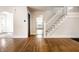 Bright living room featuring hardwood floors and a staircase with white banister and access to the kitchen at 413 E 40Th St, Indianapolis, IN 46205