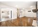 Open-concept living room with hardwood floors, staircase, fireplace, and doorway to another room at 413 E 40Th St, Indianapolis, IN 46205