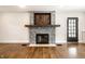 Living room featuring a stone fireplace with wooden mantle and an adjacent door to the home's exterior at 413 E 40Th St, Indianapolis, IN 46205