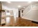 Open living room with hardwood floors, fireplace, built-in shelving, staircase, and access to the kitchen at 413 E 40Th St, Indianapolis, IN 46205