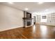 Spacious living room with a stone fireplace, wooden mantle, built-in shelving, and gleaming hardwood floors at 413 E 40Th St, Indianapolis, IN 46205