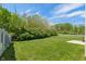 Large, grassy backyard with a view of the surrounding foliage and the neighboring fence at 4136 Orchard Valley Ln, Indianapolis, IN 46235